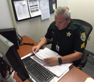 Mark Tate standing by the processing window of the Clay County Sheriff’s Office Civil Section