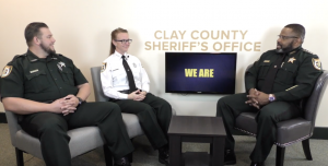 Sheriff Daniels, Deputy Freshour, and CST Thibedeaux sit in three chairs talking.
