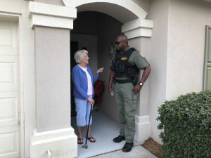 sheriff and woman speaking in doorway