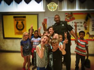 Kids making the peace sign with officer