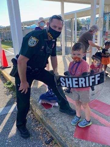 sheriff posing with kid holding shield
