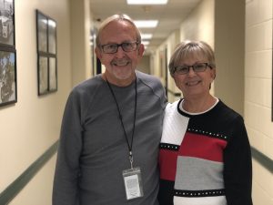 Picture of two people standing in a hallway smiling