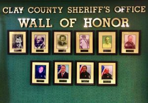 Picture of a wall of honor with photos of CCSO members who passed away in frames