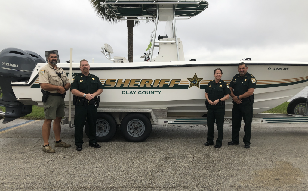 CCSO members standing in front of a Marine Unit boat
